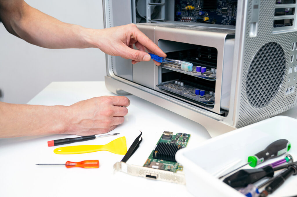 Technician working inside an open desktop computer